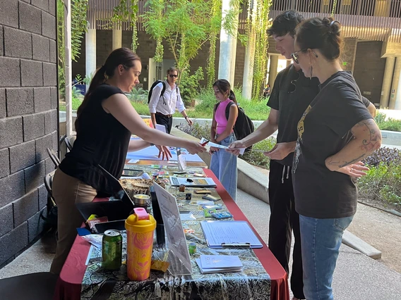 Students speaking with a tabling participant at the 2024 ENR2 Birthday Party