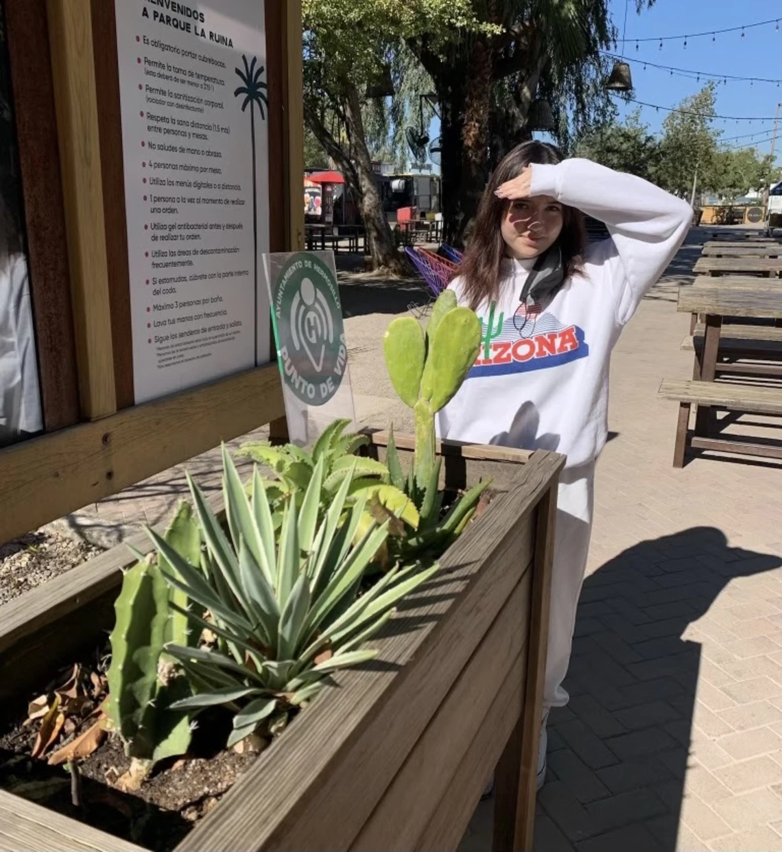 UA student Eva Quintanar standing by cacti in a planter.