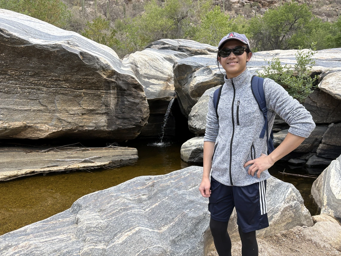 Minh Ngo in front of a waterfall
