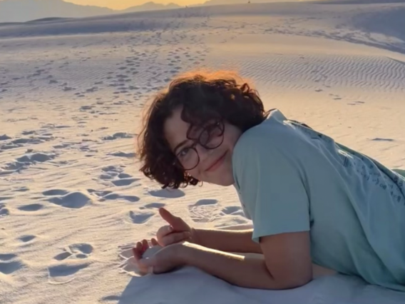 Isabel Baron lying on desert sands