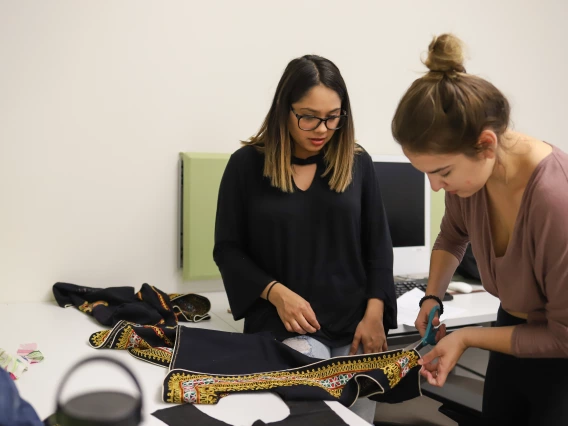 Two women modifying a garment together