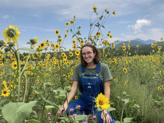Chloe Penna outside among a field of sunflowers