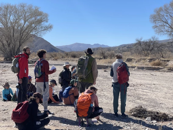 Students observing the landscape from an empty wash