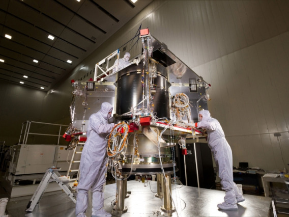 Scientists in protective gear working on a space probe