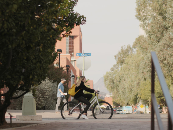 A girl riding a bicycle around the University of Arizona