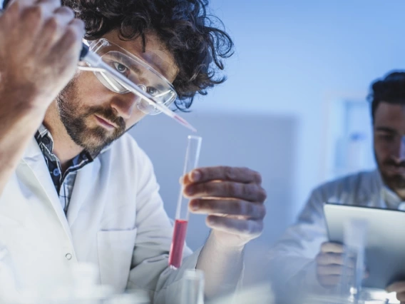 A scientist carefully adding a chemical to a test tube