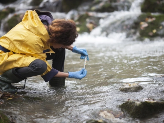 A woman taking a sample from a river