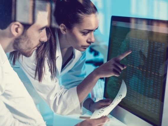 Two researchers looking at data on a computer screen together