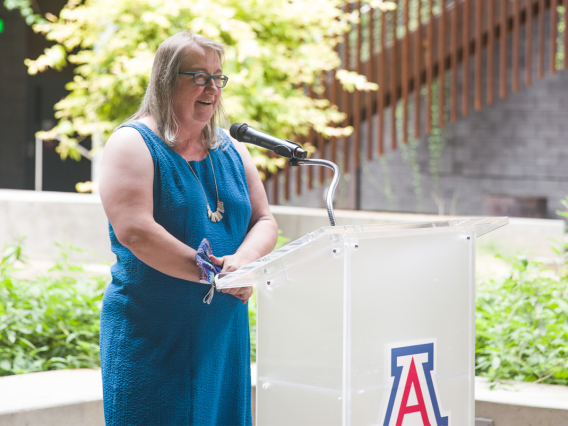 Diana Liverman speaking at a podium in the ENR2 courtyard