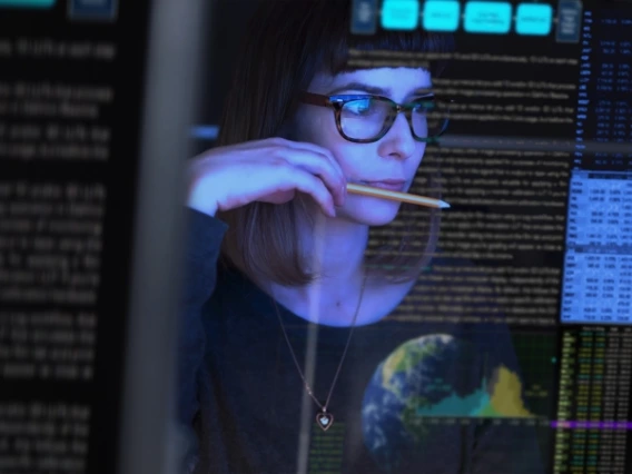 A woman examining data displayed on a computer screen