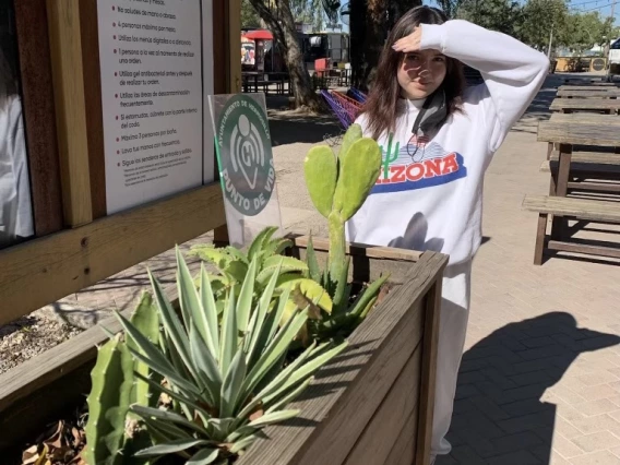 UA student Eva Quintanar standing by cacti in a planter.