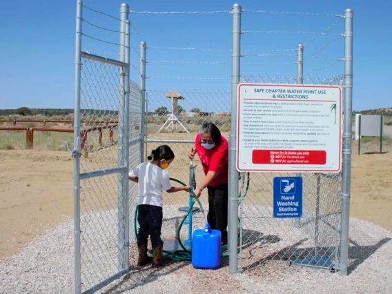 Navajo Nation family collecting water from local well