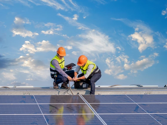 Two people installing solar panels