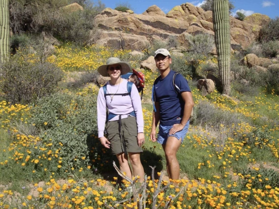 Two people standing among flowers in the Sonoran Desert