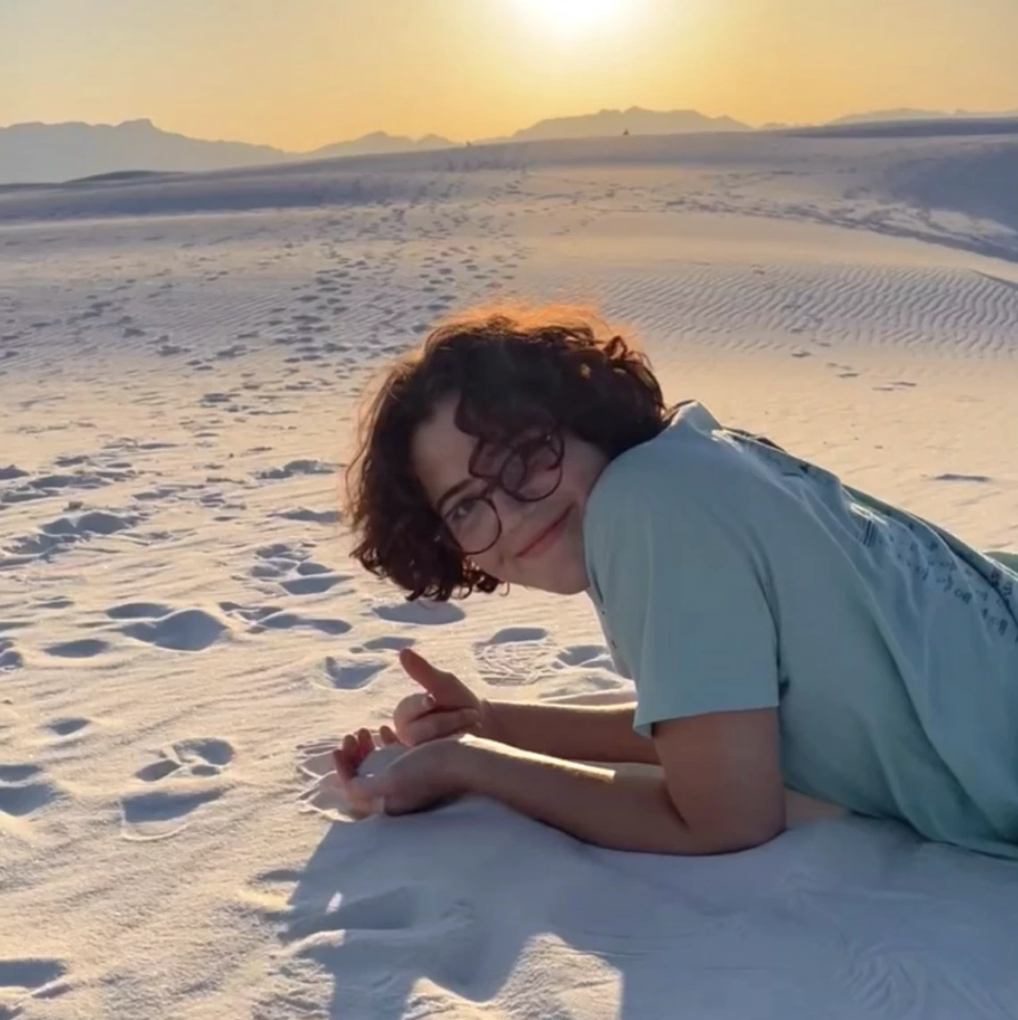 Isabel Baron lying on desert sands