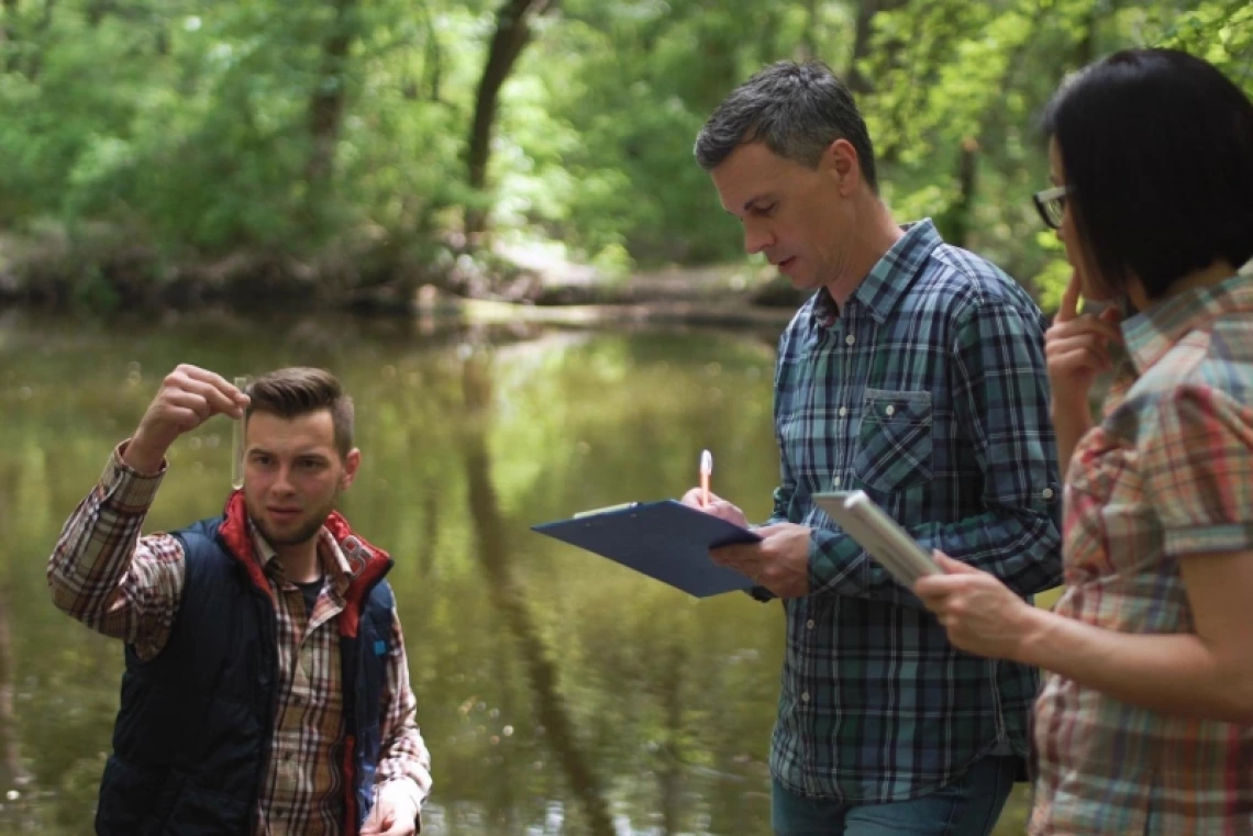 Researchers taking water samples and talking together