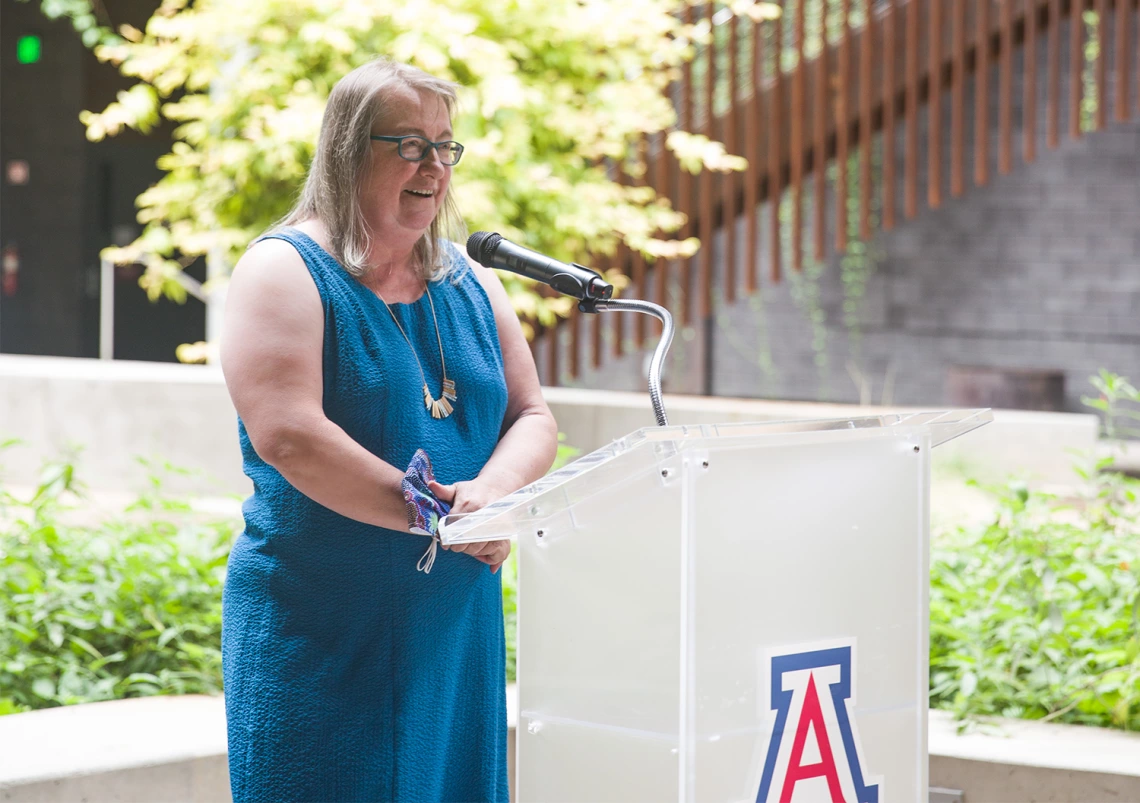 Diana Liverman speaking at a podium in the ENR2 courtyard