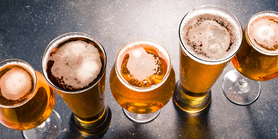 A row of differing beer glasses and beer types
