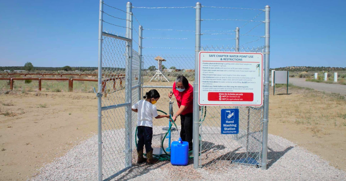 Navajo Nation family collecting water from local well