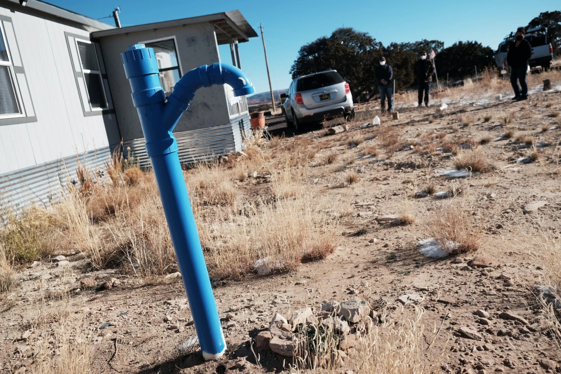 A blue water spout in front of a house on Navajo land.