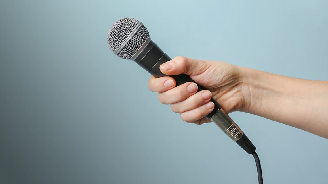 hand holding out microphone for an interview