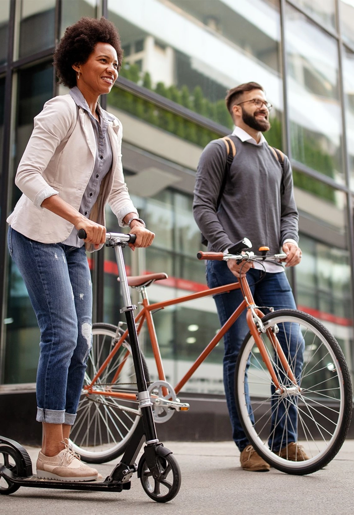 two young professionals on a bike and a scooter