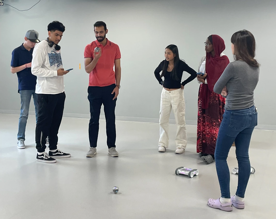 Students stand in white room