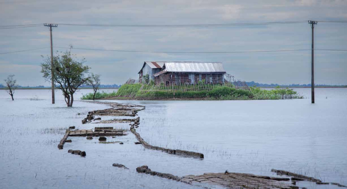 Flooding surrounding a home on a small hill.