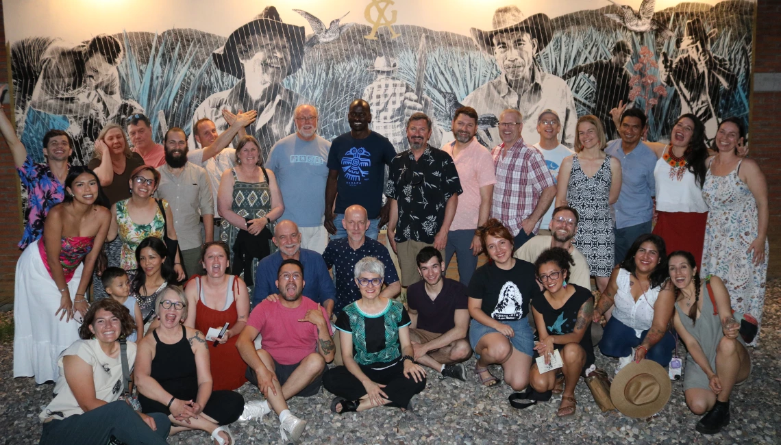 The EMIGRA team posing in front of wall mural at night.