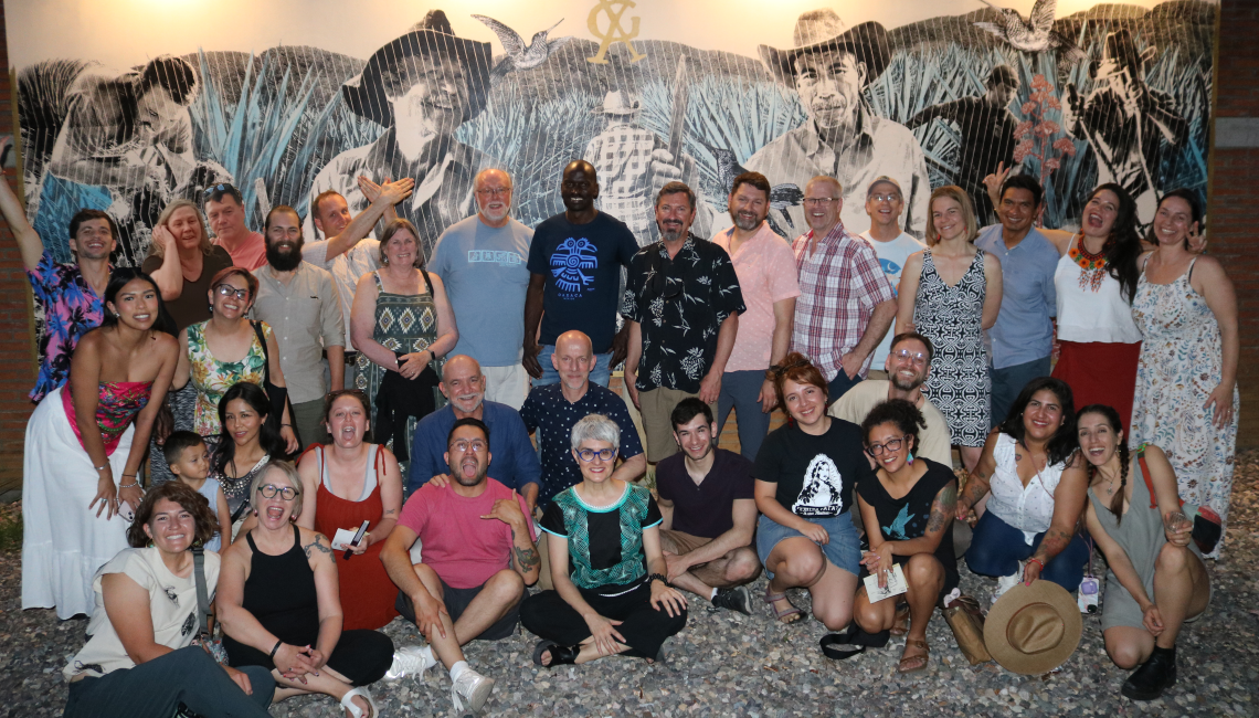 The EMIGRA team posing in front of wall mural at night.