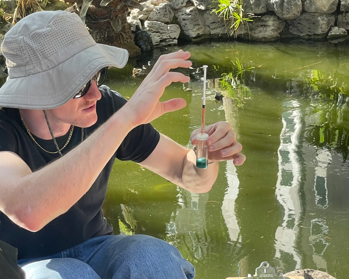 Jack holding up a water sample outside