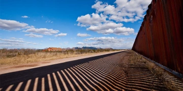 A close-up of the Arizona-Mexico border with a shadow created by the wall