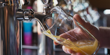 A beer being poured into a glass from a tap