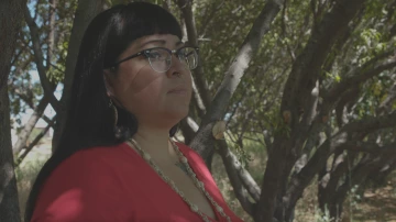 Jacele standing beneath a shaded tree