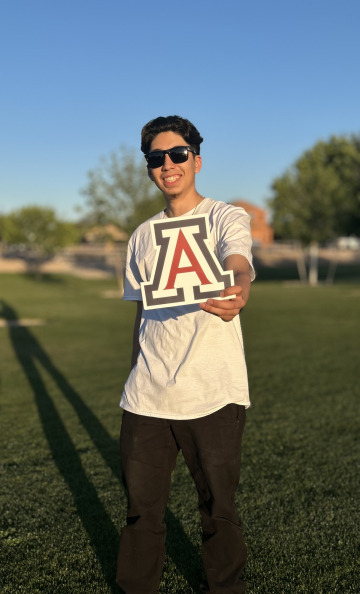 Ruben Aguirre posing with a U of A Block A outside