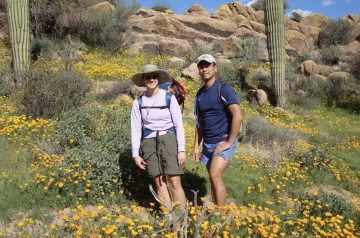 Karen Hastings, MD, PhD, pictured with her husband, Keith, in a field of wildflowers.
